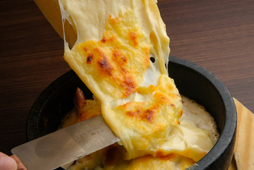おすすめのチーズ3種と目の前でかけるラクレットチーズが豪快な『四種チーズの石焼きリゾット』